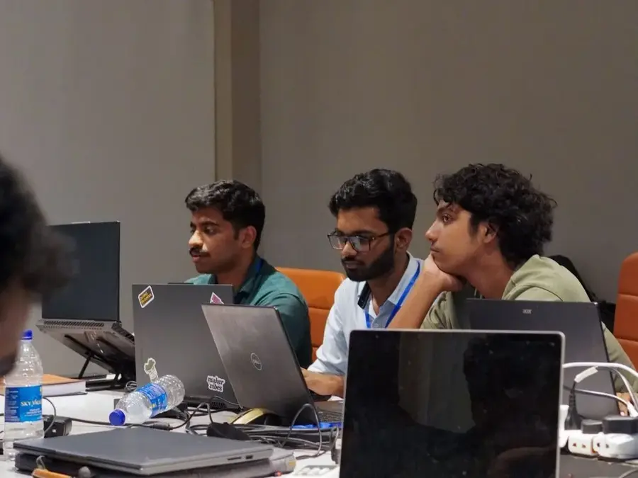 DeVoc students working together on laptops during a hackathon
