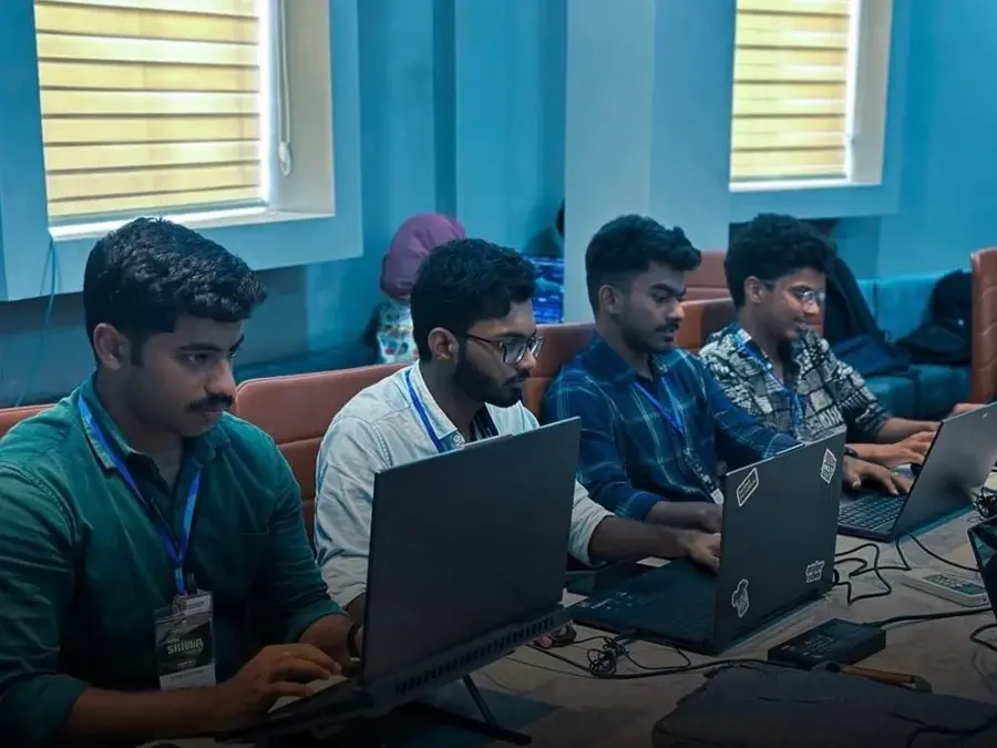 DeVoc students working together on laptops during a hackathon
